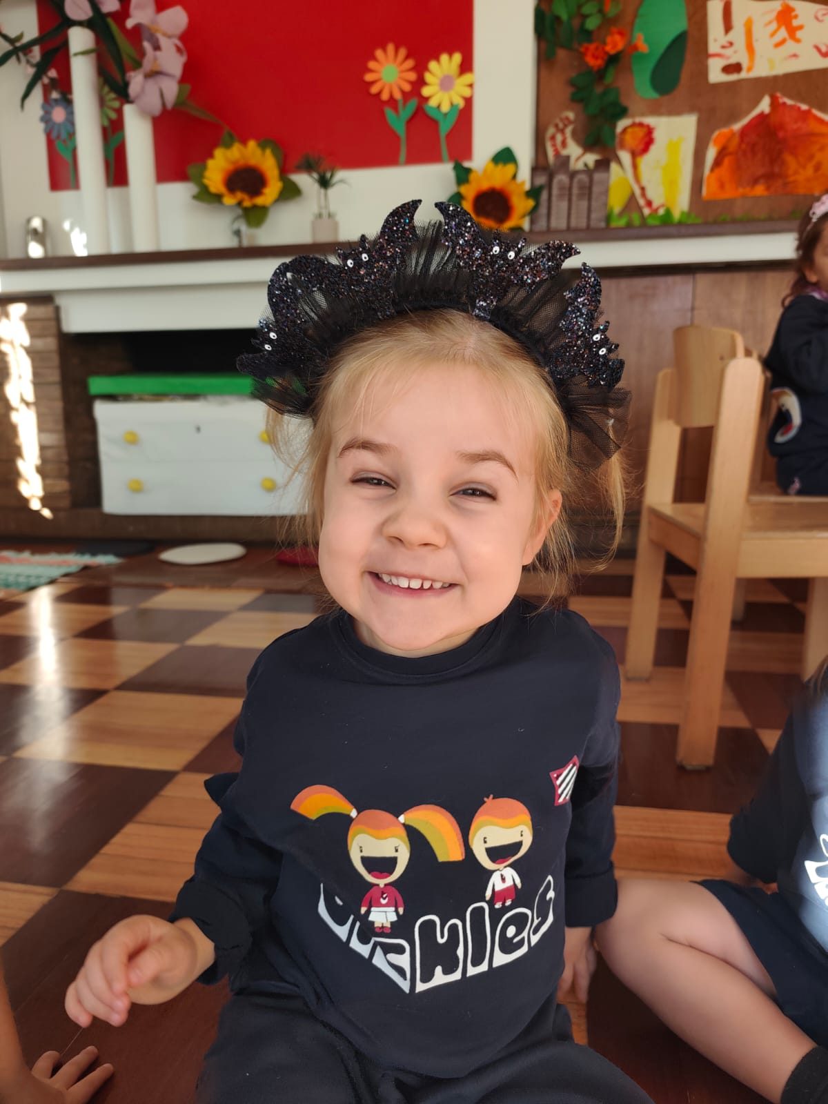 Criança sorridente com bandolete de Halloween