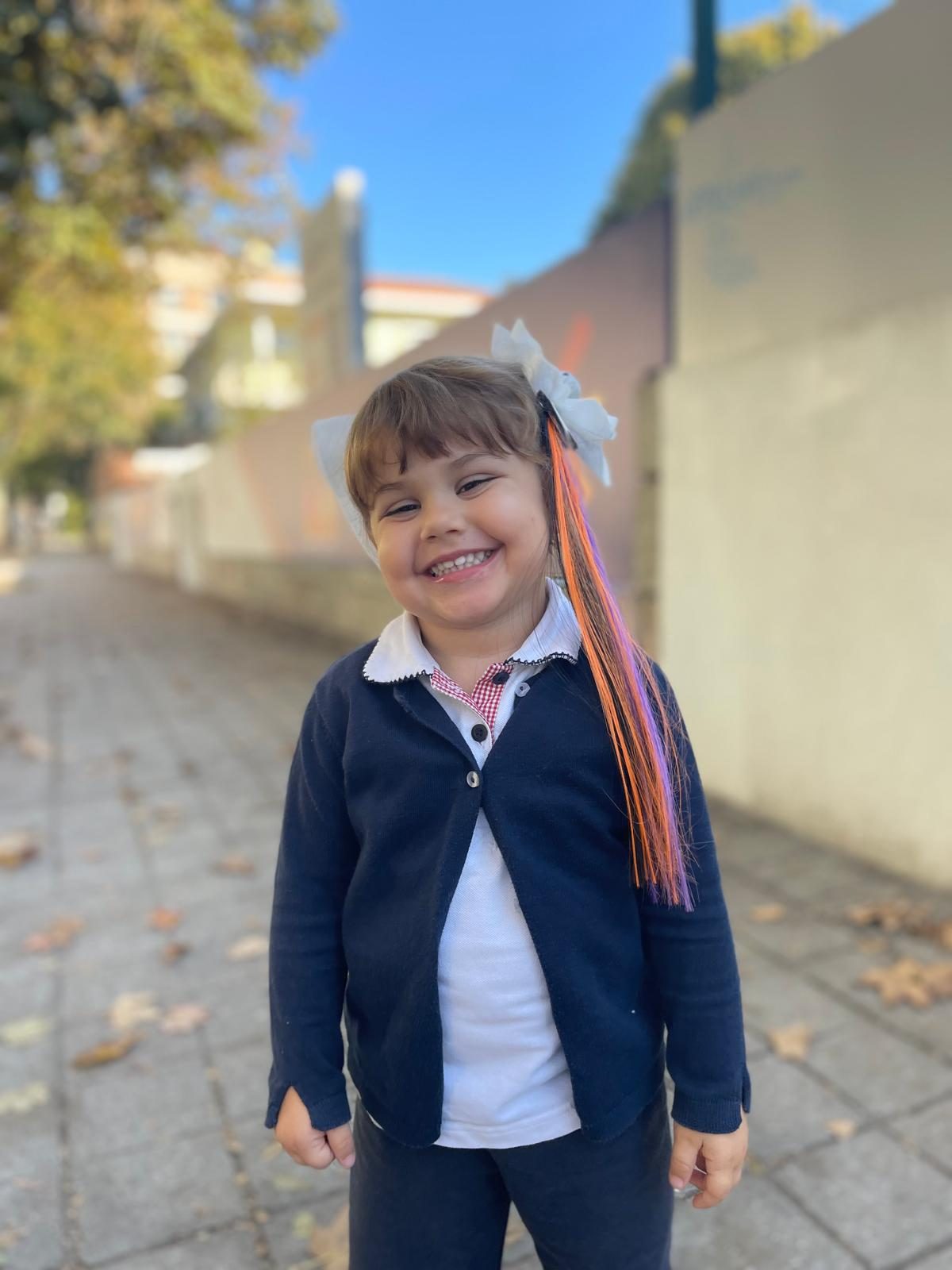 Criança com mechas coloridas no cabelo