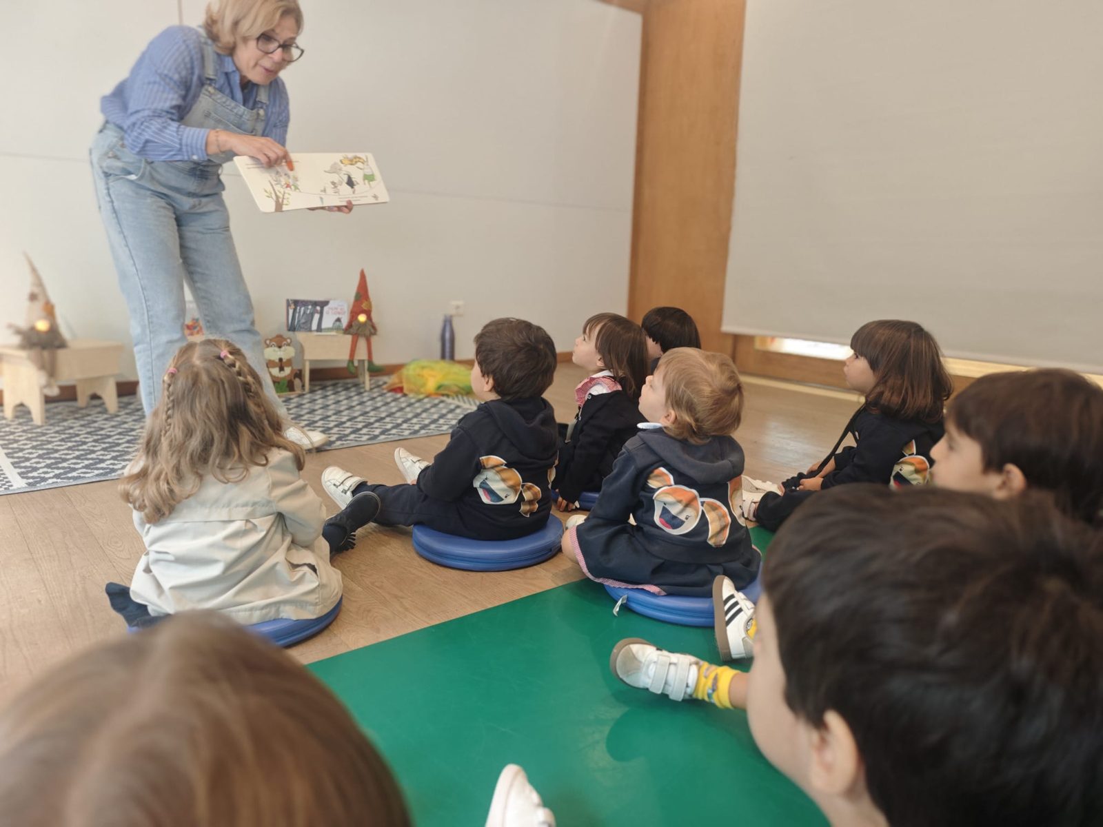 Crianças da Sala dos Pandas a ouvir uma história na biblioteca